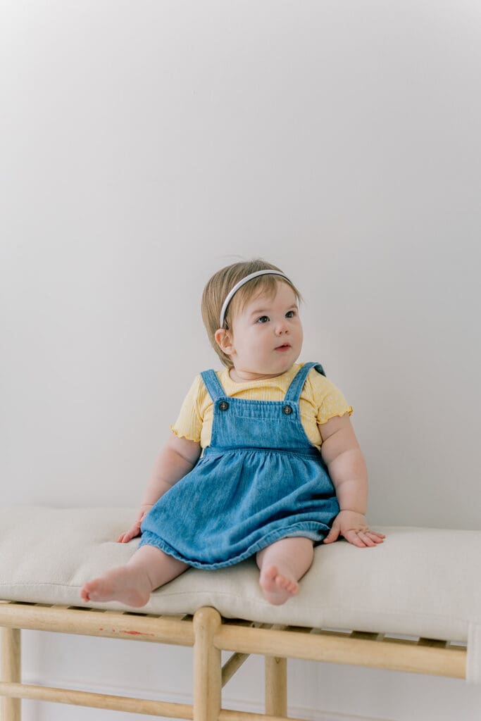 Richmond baby milestone photographer session showing a chubby one-year-old and her big sister announcement.