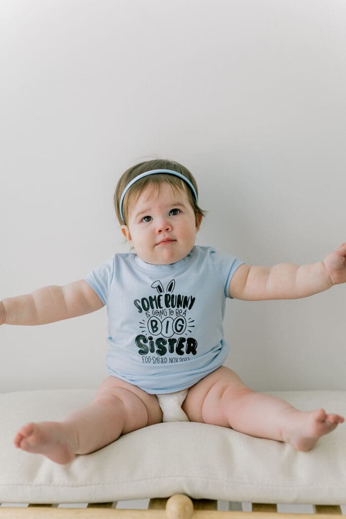 Richmond baby milestone photographer session showing a chubby one-year-old and her big sister announcement.