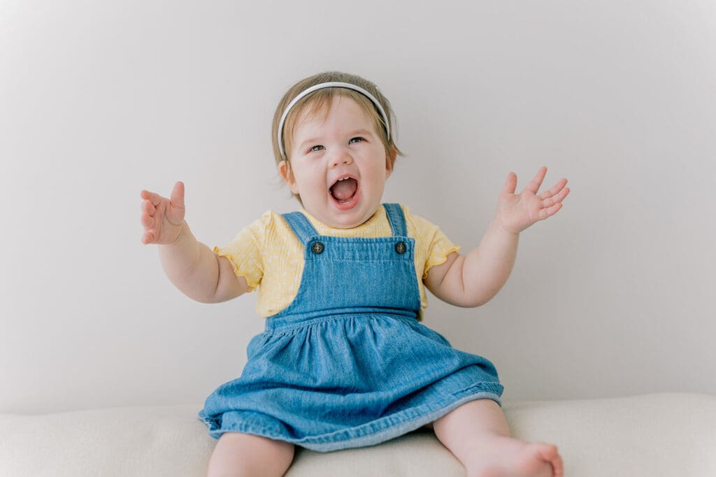 Richmond baby milestone photographer session showing a chubby one-year-old and her big sister announcement.