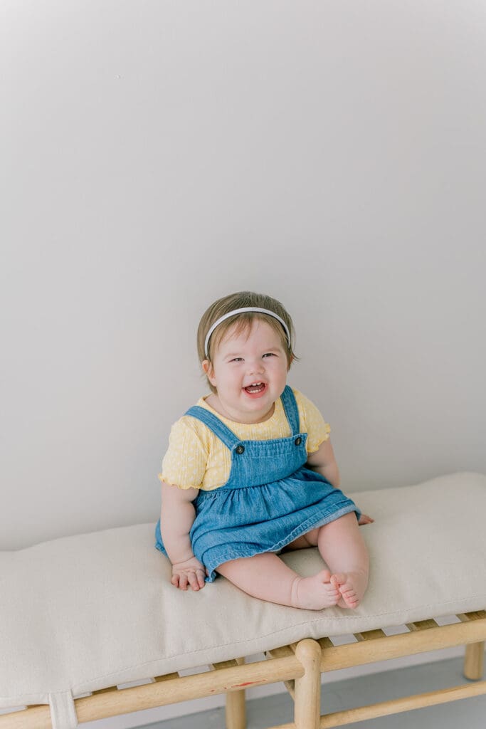 Richmond baby milestone photographer session showing a chubby one-year-old and her big sister announcement.