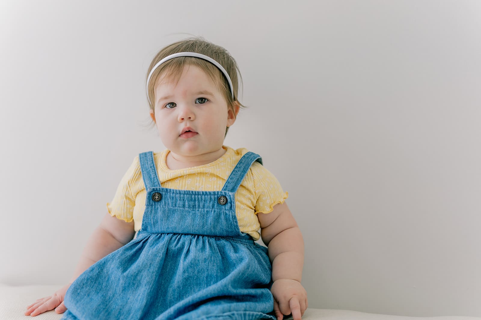 Richmond baby milestone photographer session showing a chubby one-year-old and her big sister announcement.