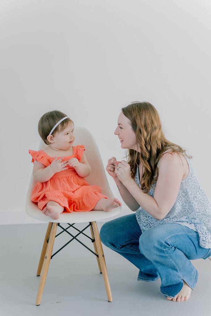 Richmond baby milestone photographer session showing a chubby one-year-old and her big sister announcement.