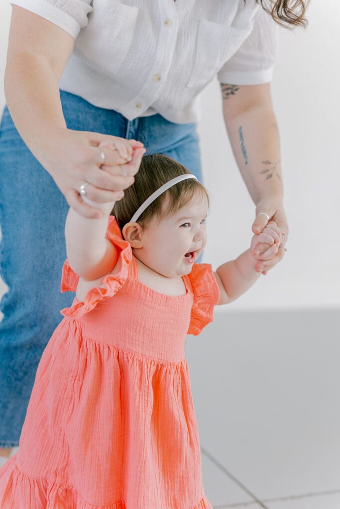 Richmond baby milestone photographer session showing a chubby one-year-old and her big sister announcement.