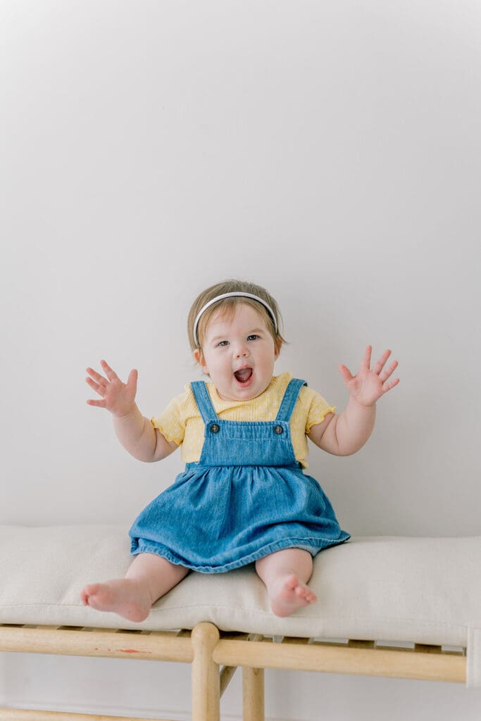 Richmond baby milestone photographer session showing a chubby one-year-old and her big sister announcement.