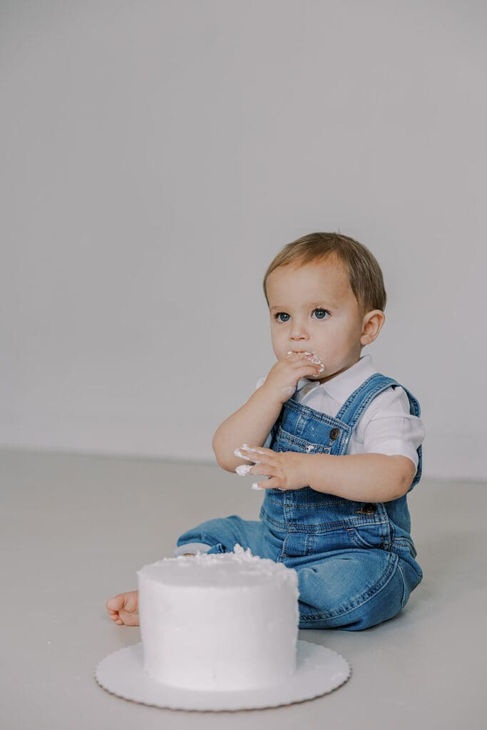 Cake smash photography in Richmond session featuring baby Lincoln enjoying his first birthday cake at our studio.