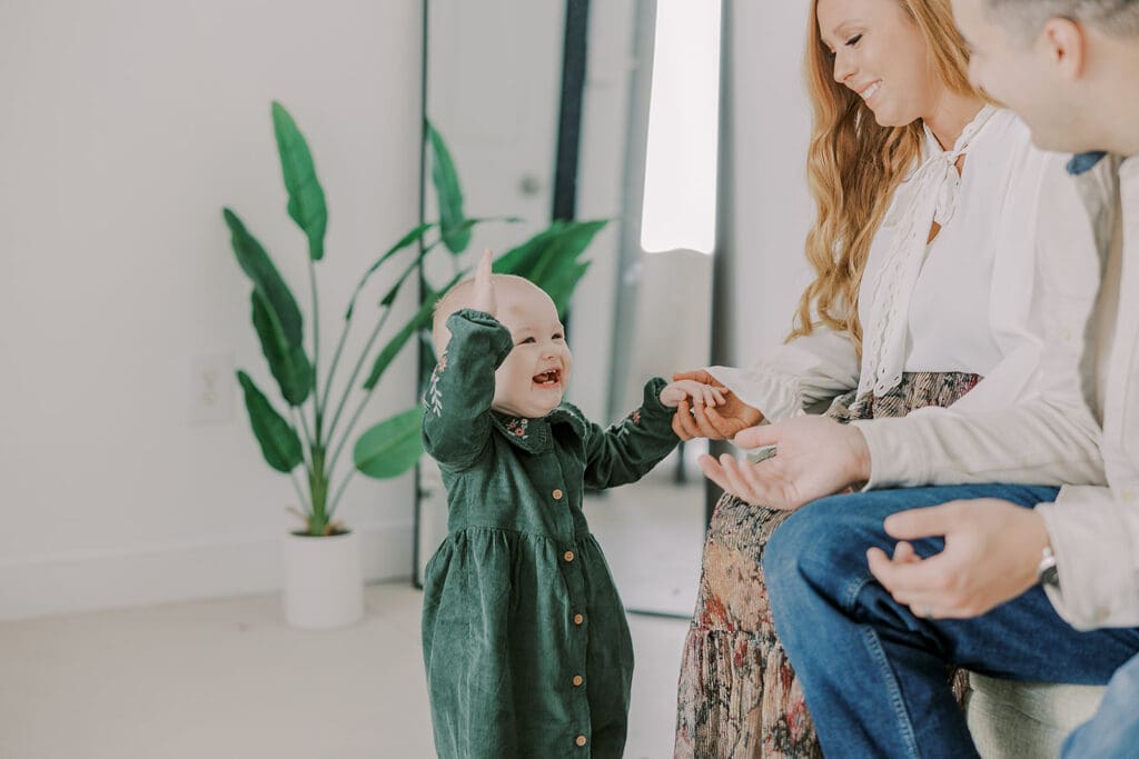 Richmond studio family session featuring the stylish Cooney family celebrating their daughter's first birthday with joyful expressions.