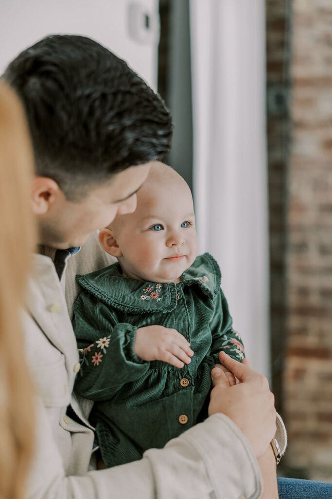 Richmond studio family session featuring the stylish Cooney family celebrating their daughter's first birthday with joyful expressions.