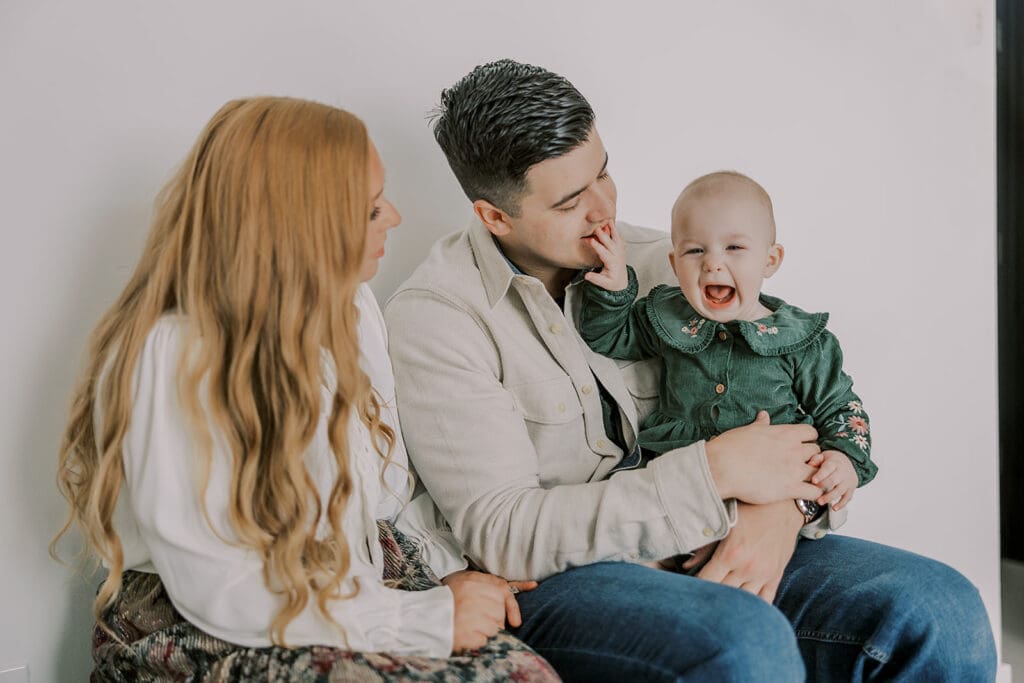 Richmond studio family session featuring the stylish Cooney family celebrating their daughter's first birthday with joyful expressions.