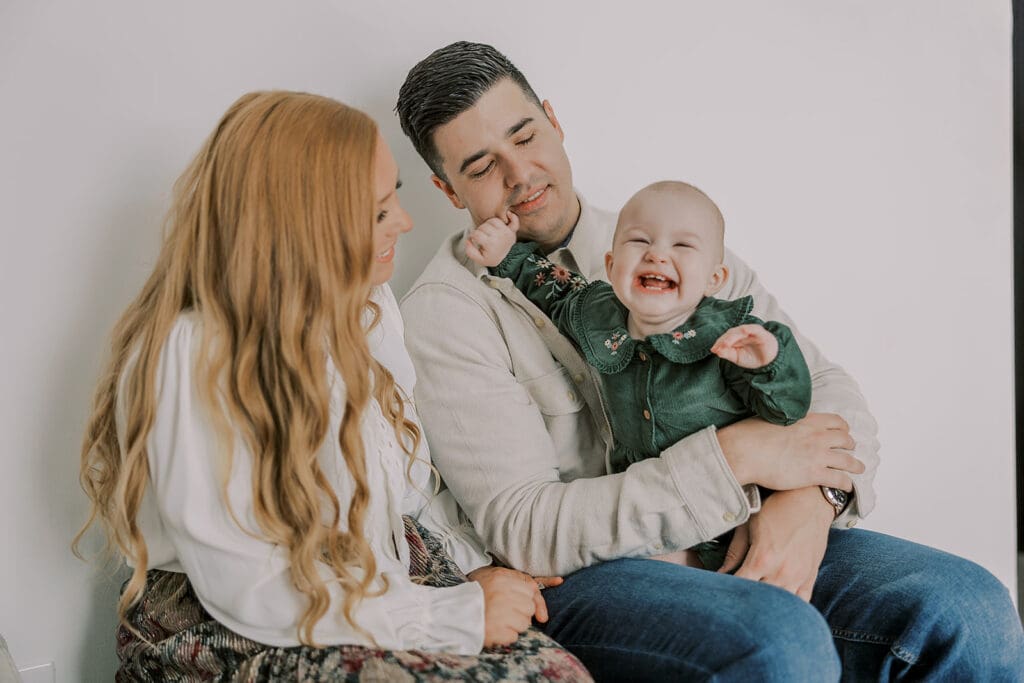 Richmond studio family session featuring the stylish Cooney family celebrating their daughter's first birthday with joyful expressions.