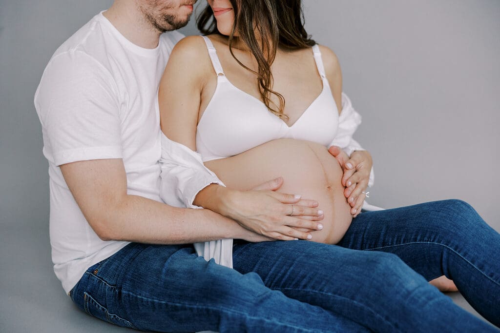 Studio maternity photography in Richmond showing the Holguins with flowers, ultrasound pictures and simple elegant backdrops.