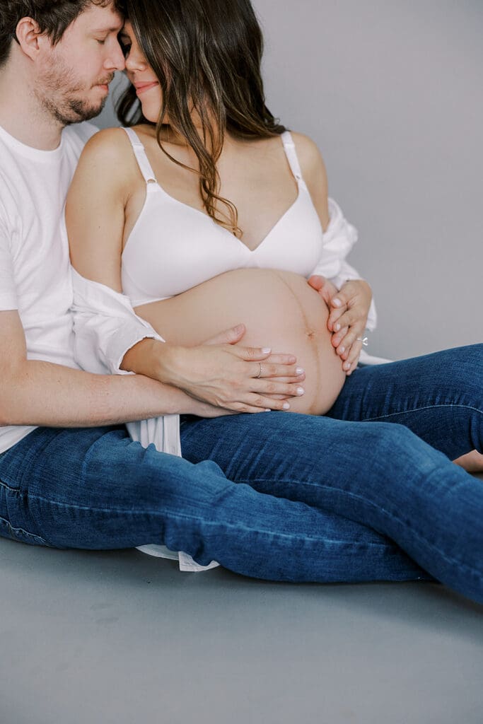 Studio maternity photography in Richmond showing the Holguins with flowers, ultrasound pictures and simple elegant backdrops.