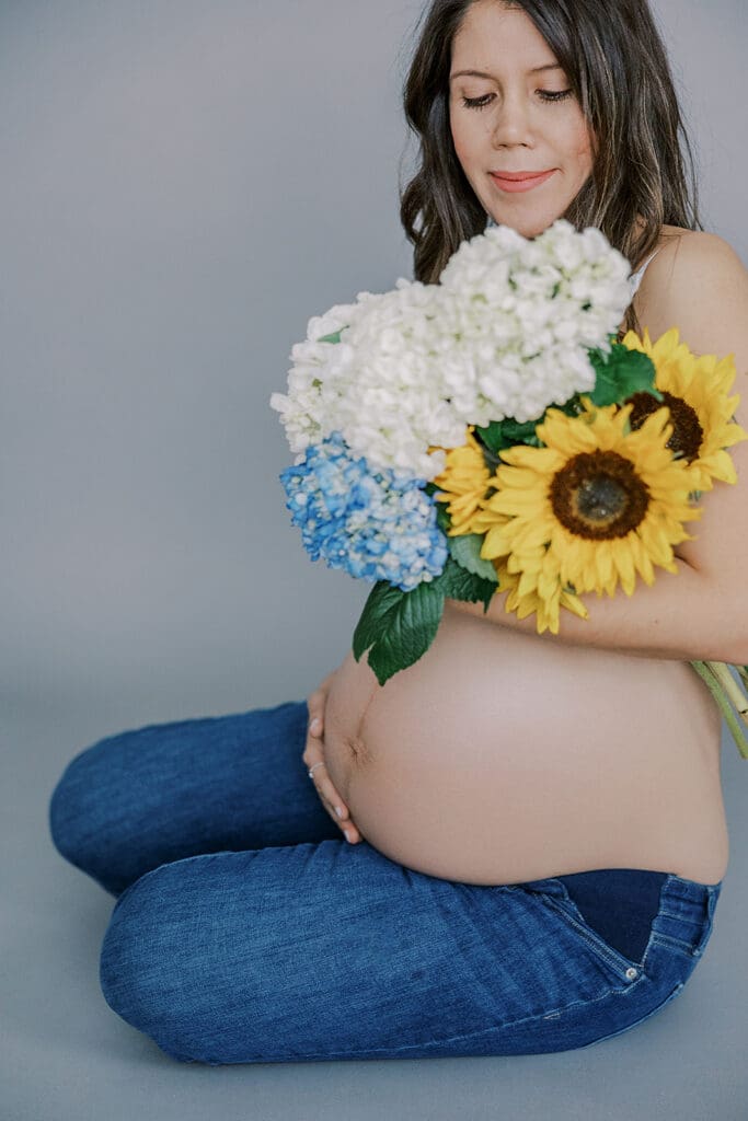 Studio maternity photography in Richmond showing the Holguins with flowers, ultrasound pictures and simple elegant backdrops.