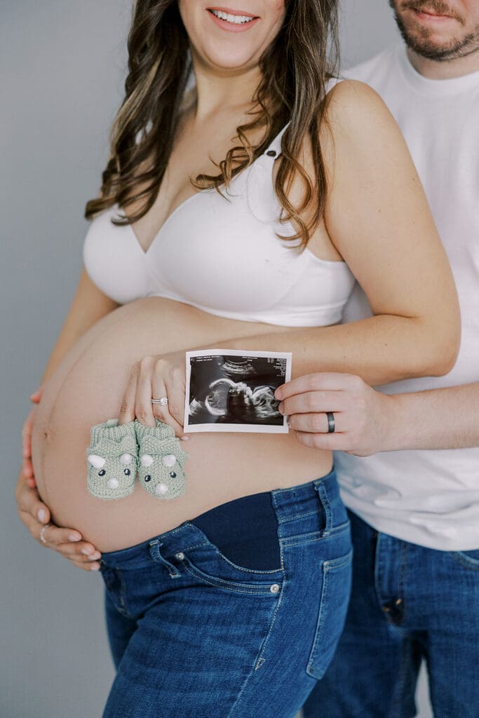 Studio maternity photography in Richmond showing the Holguins with flowers, ultrasound pictures and simple elegant backdrops.