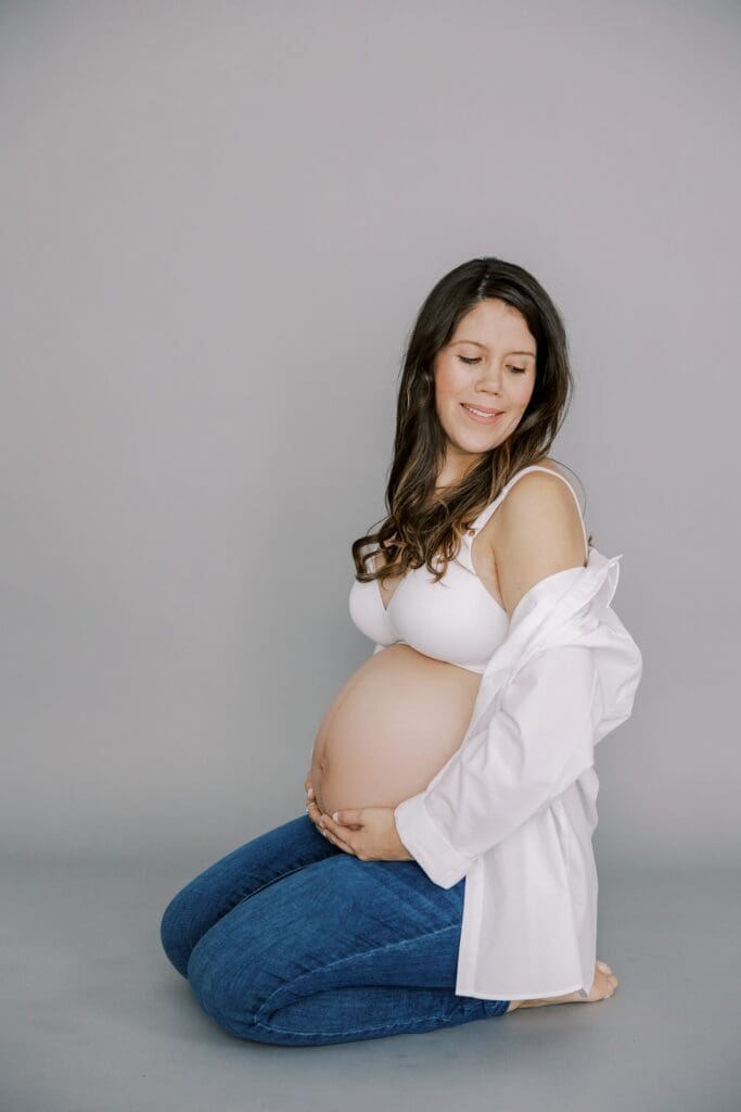 A pregnant woman poses with a perfect maternity photo outfit.