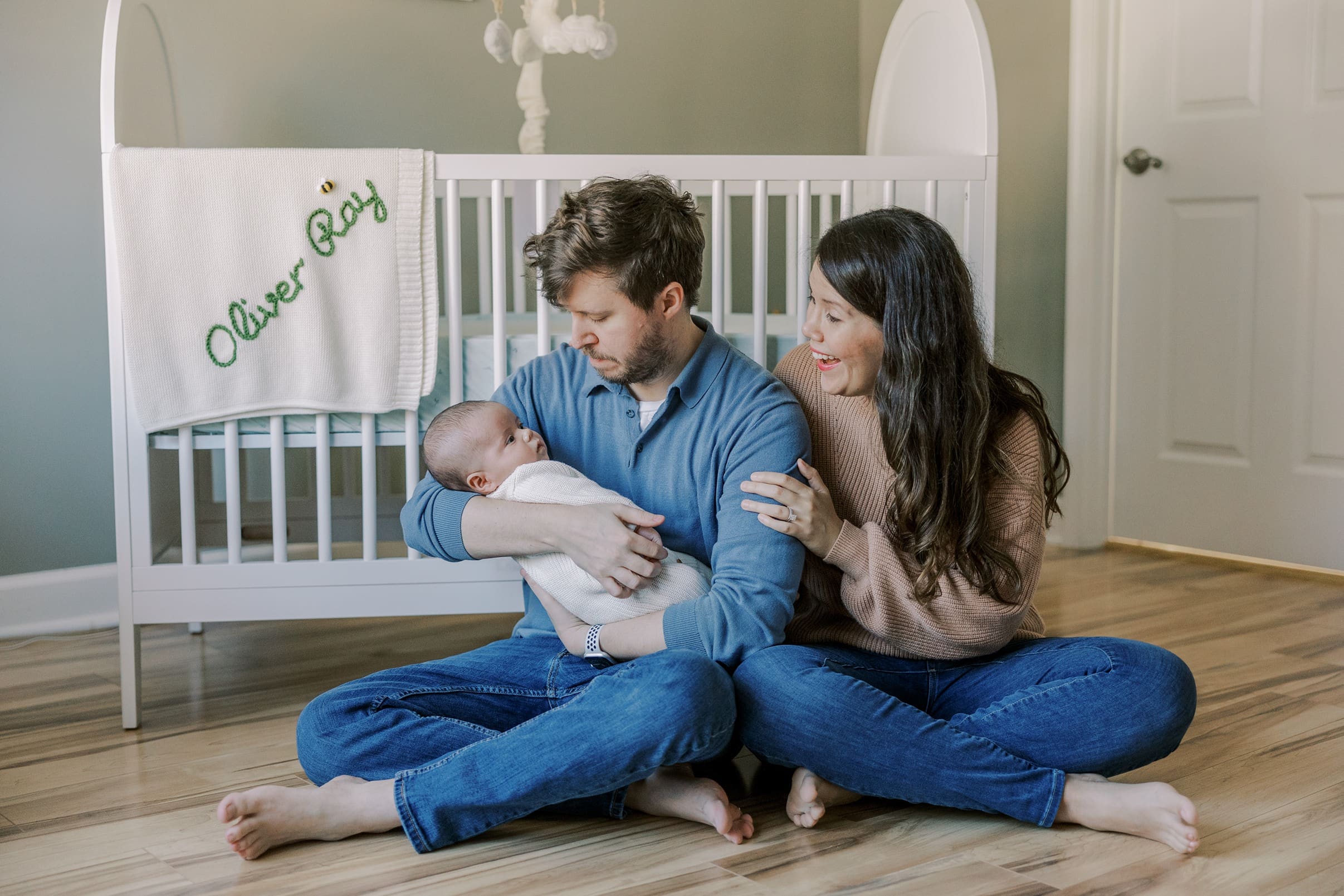 A mother and father with their baby during their in-home newborn session