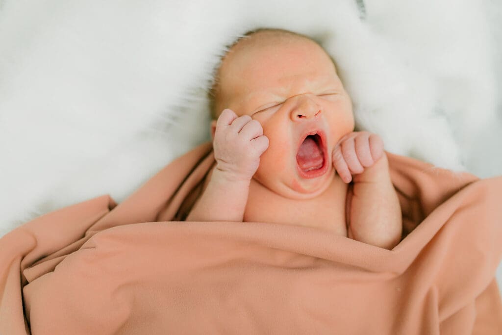 Baby Ember yawns during her in-home newborn photography session.