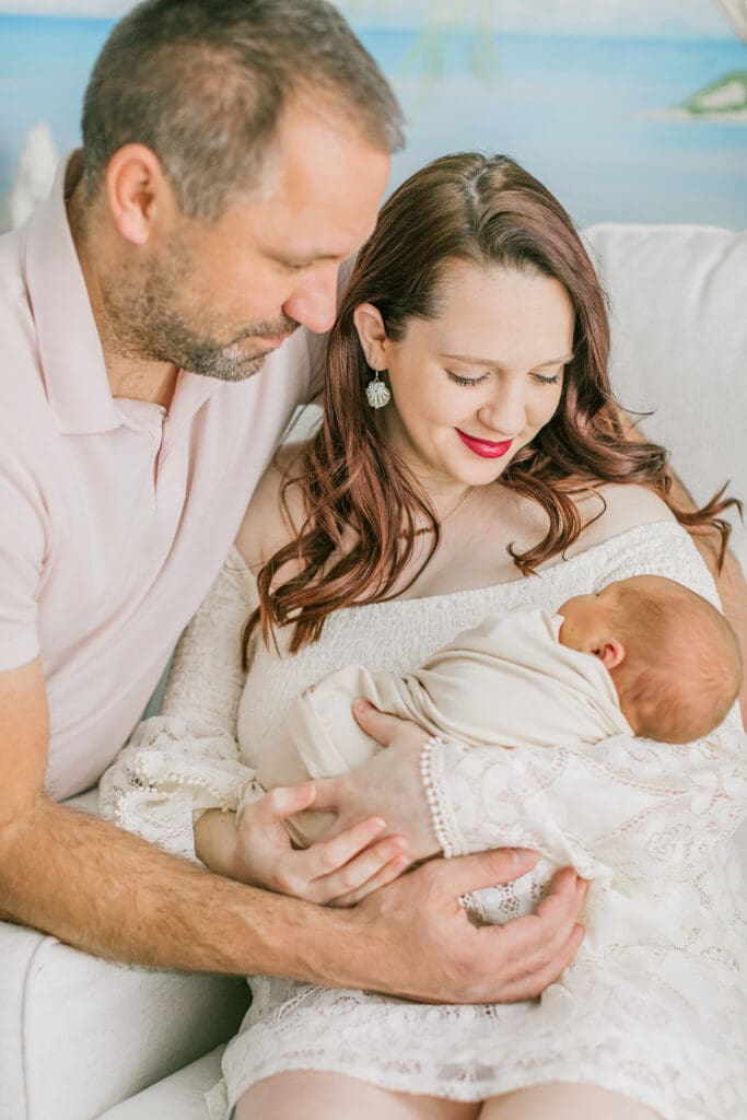 Baby Ember poses with her parents during her in-home newborn photography session.