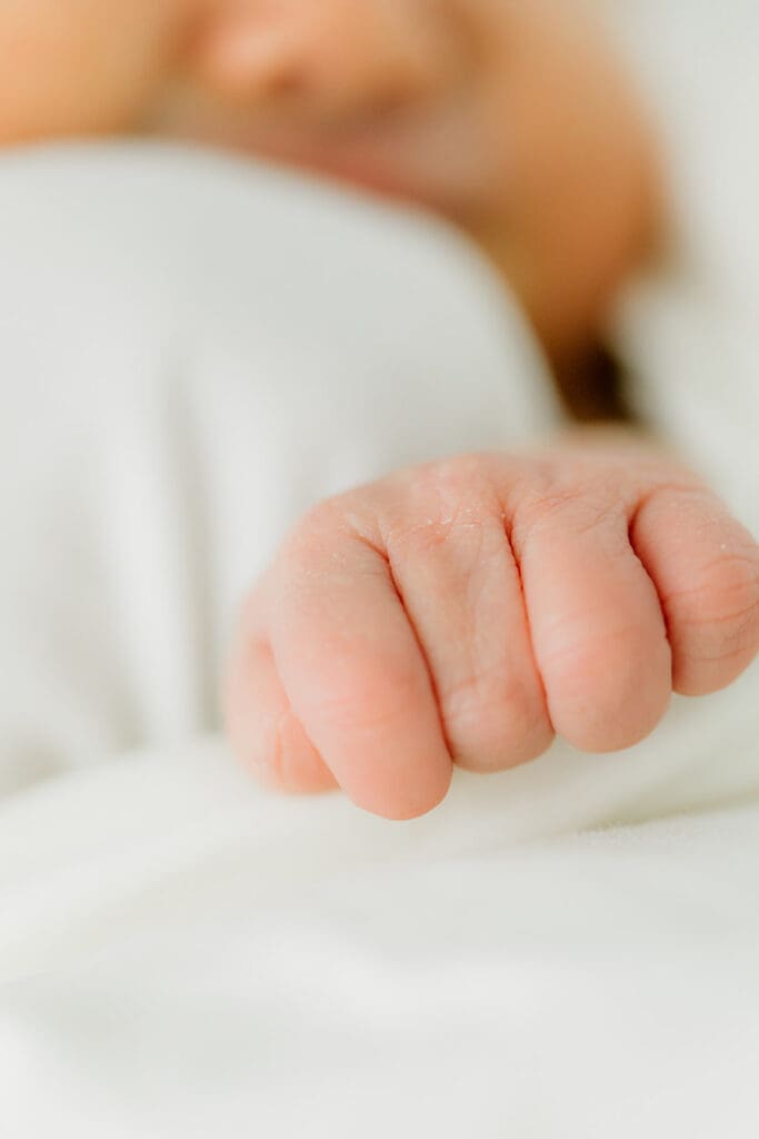 Baby Ember gives a hand during her in-home newborn photography session.