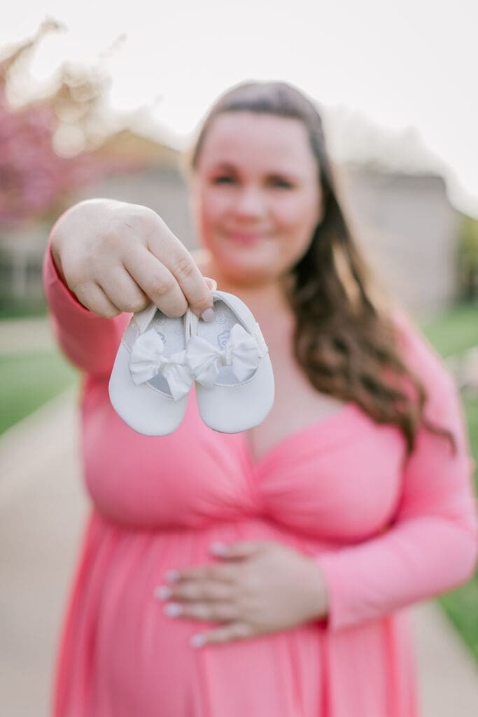 VMFA spring maternity photography featuring Shannon in a flowing pink dress with cherry blossoms and grand architecture.