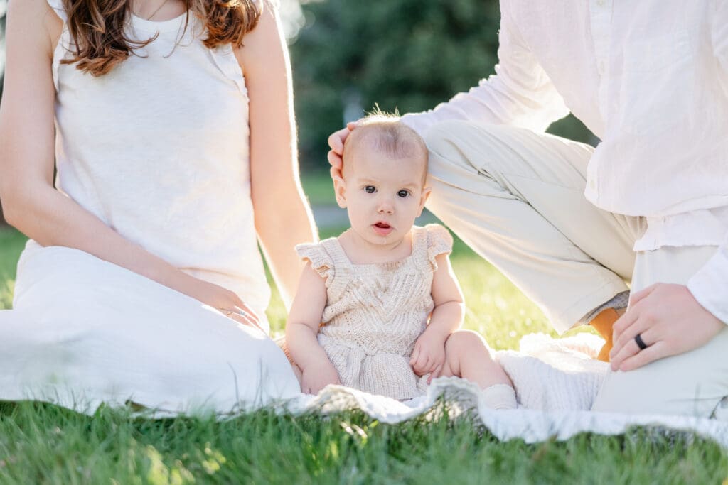 Family poses with their baby girl during their family photography session in the cherry blossoms in Richmond.
