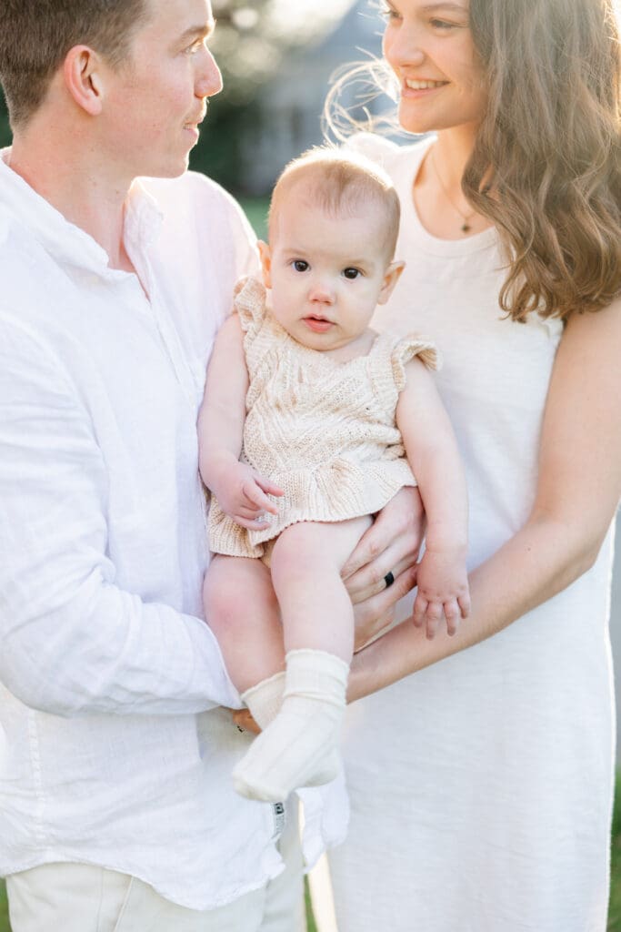 Family poses with their baby girl during their family photography session in the cherry blossoms in Richmond.