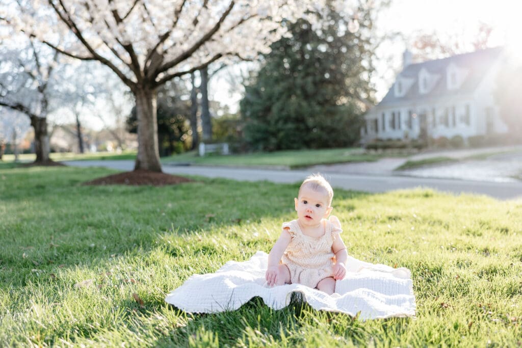 Family poses with their baby girl during their family photography session in the cherry blossoms in Richmond.